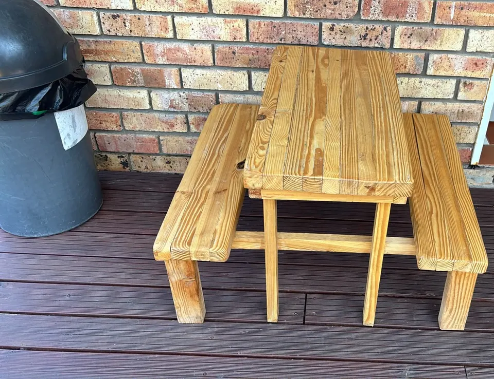 Child-sized wooden picnic table with a slatted top and a bench on each side, in a natural wood tone
