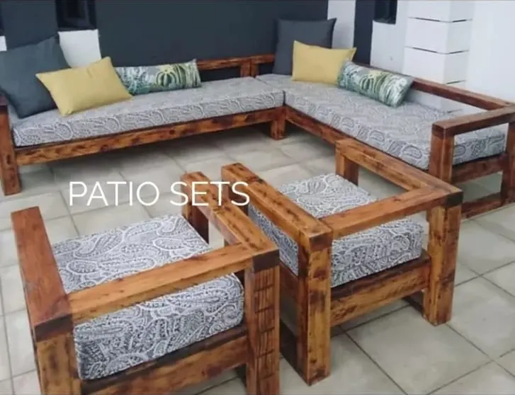 Handmade outdoor lounge: a corner sofa and two armchairs in chunky stained timber with grey paisley cushions