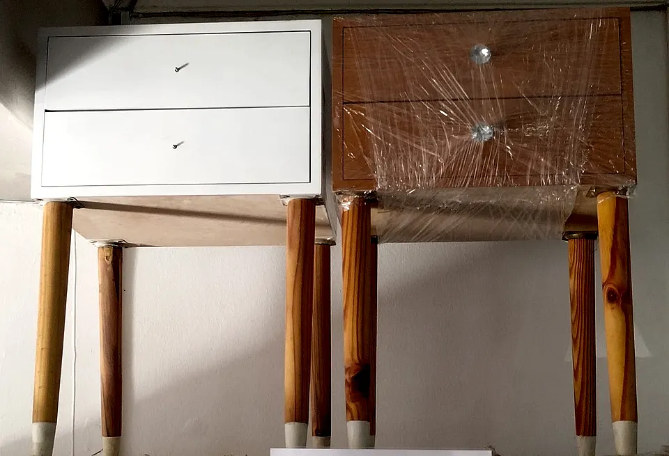 Two two-drawer bedside pedestals on turned legs, one white and one in a timber-look finish