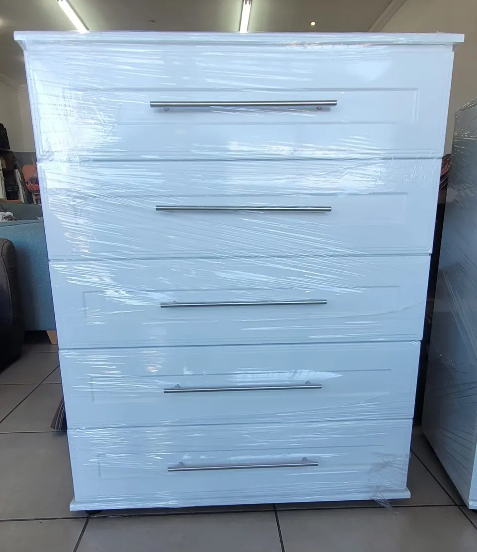 White five-drawer chest of drawers with raised-panel drawer fronts and full-length bar handles
